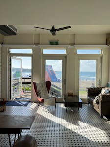 Bright interior with sea view, featuring stylish armchair and sofa, perfect for relaxation.