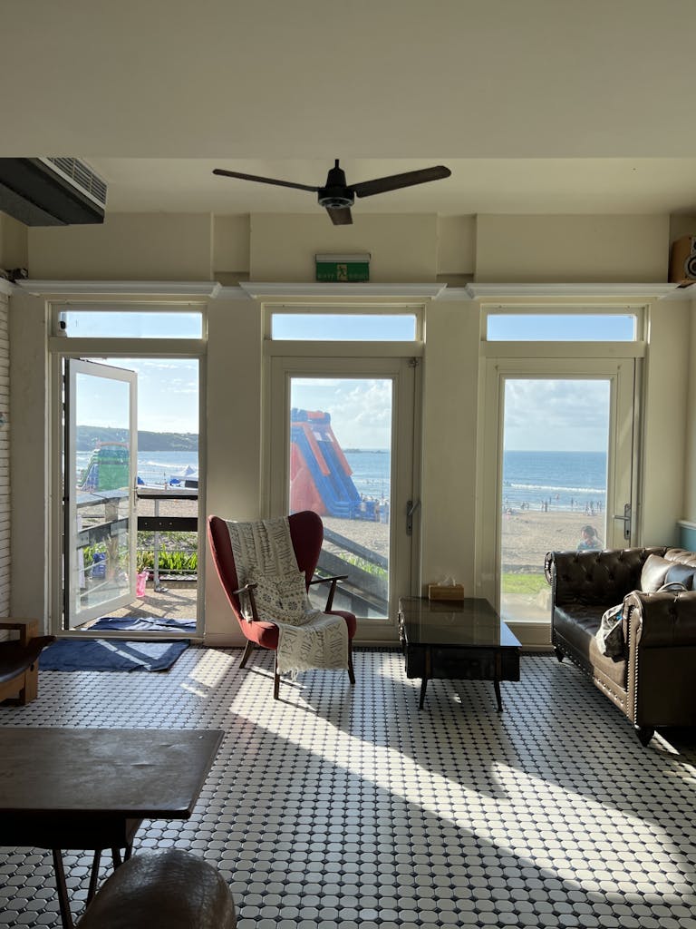 Bright interior with sea view, featuring stylish armchair and sofa, perfect for relaxation.